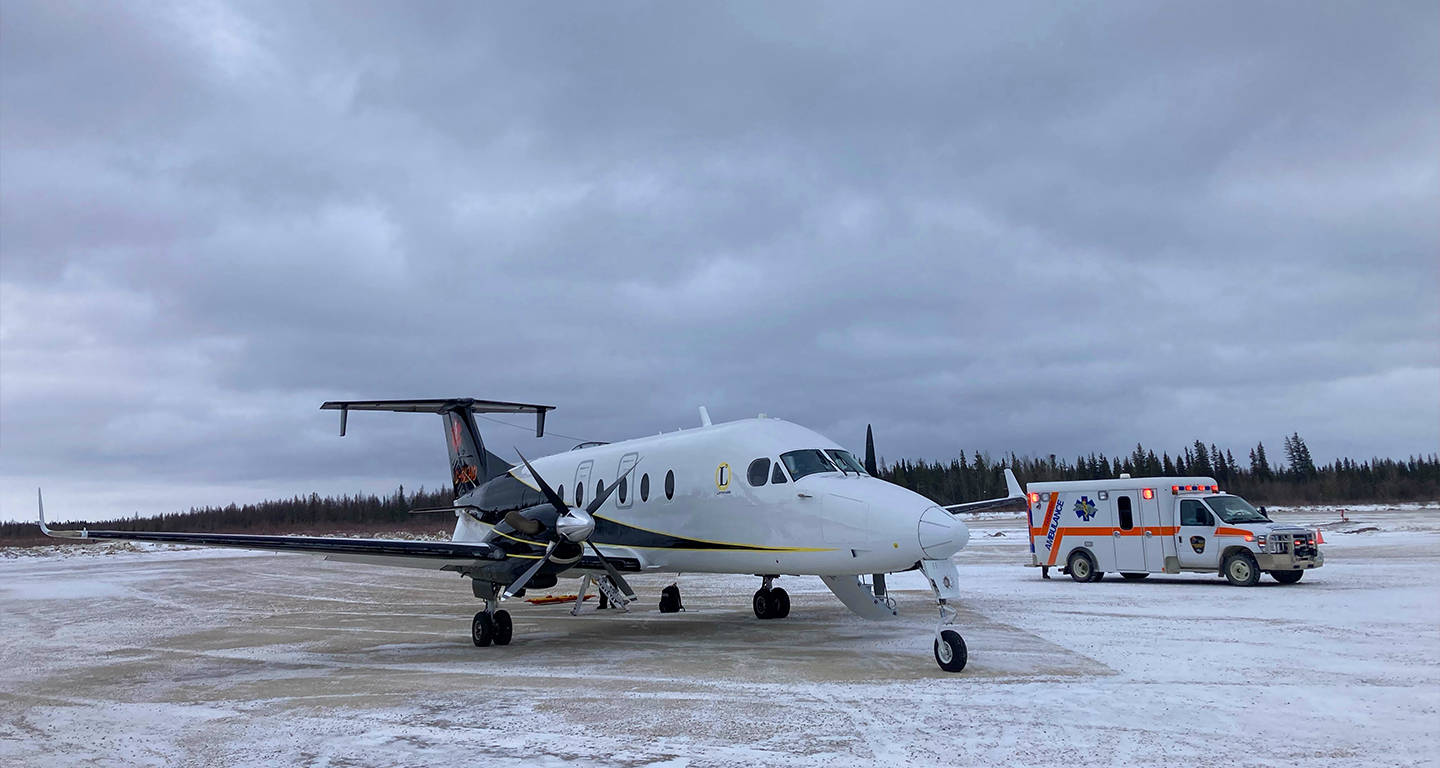 beech 900-d jet and ambulance on runway in winter