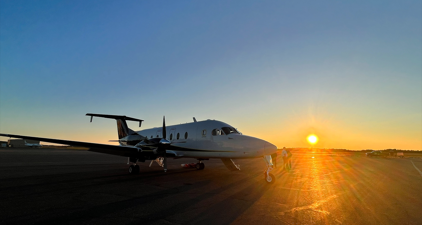 beech 900-d on runway during sunset
