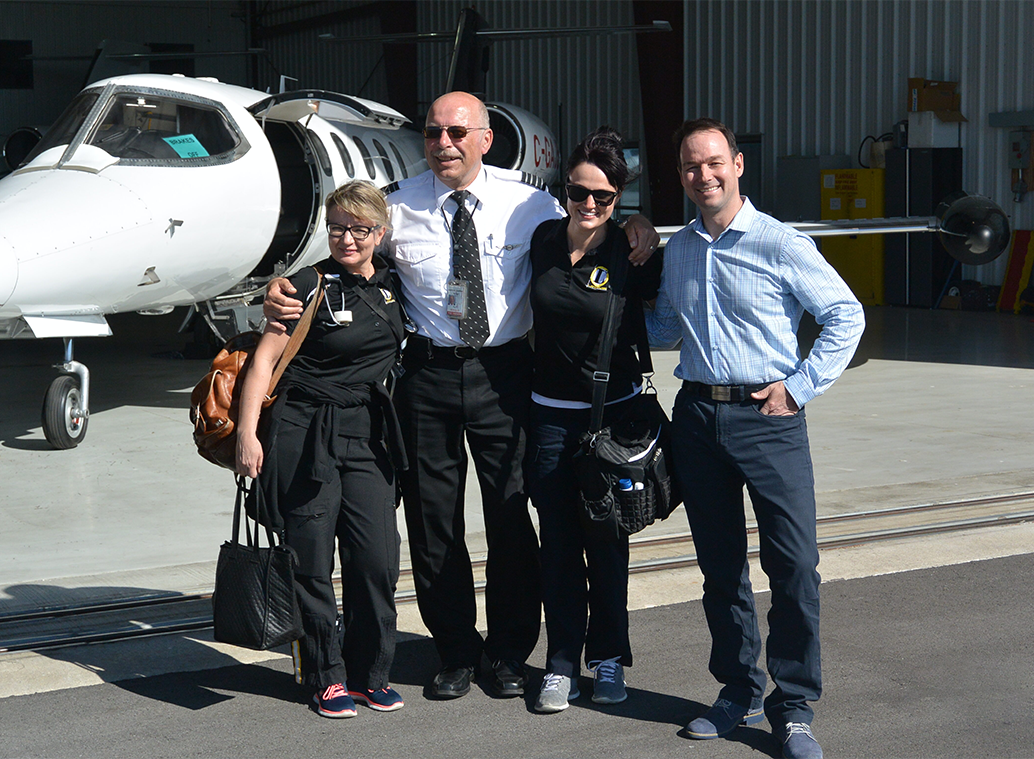 four people in front of a jet